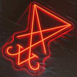 May include: A red neon sign in the shape of a five-pointed star with an inverted triangle inside. The sign is on a white background.