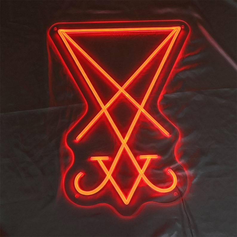 May include: A red neon sign depicting the sigil of Baphomet, a symbol associated with Satanism.