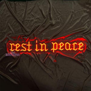 K&ouml;nnte beinhalten: Ein Neon-Schild mit den Worten "Ruhe in Frieden" in einer gotischen Schriftart. Das Schild leuchtet in einem leuchtenden Gelb und ist vor einem dunkelroten Hintergrund platziert.