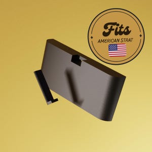 May include: A dark gray, angled guitar part with a black accent piece. The image includes a circular emblem with the text "Fits AMERICAN STRAT" and an American flag.