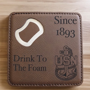 May include: Brown leather coaster with a bottle opener, the text "Since 1893", "Drink To The Foam", and a US Navy anchor logo.