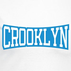 May include: White t-shirt with a blue and white graphic that says "CROCKLYN".