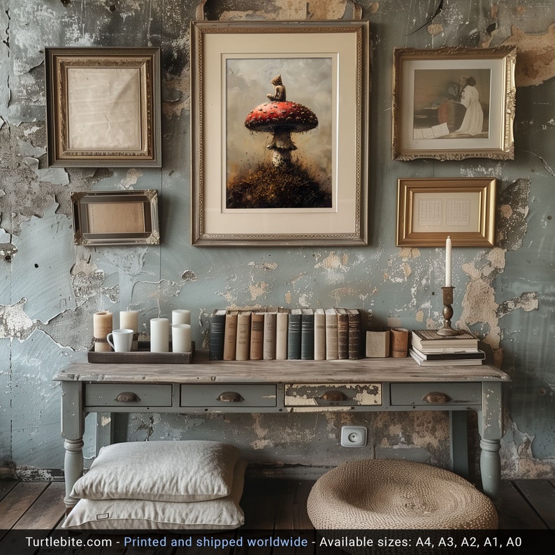 May include: A rustic wooden table with three drawers, a gray painted finish, and a distressed look. The table is decorated with a variety of items, including a framed print of a mushroom with a small figure sitting on top, a stack of books, and a candle holder with a lit candle. The table is set against a backdrop of a weathered, gray wall.