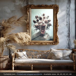 May include: A framed print of a surreal, multi-headed creature with a gaping mouth, set against a neutral background. The print is displayed in a gold-coloured frame and is surrounded by a sofa and a plant.