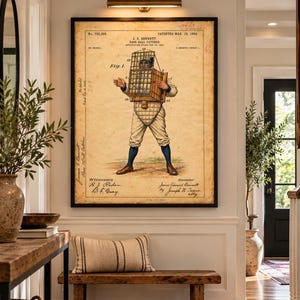 May include: A framed vintage patent print titled J. E. Bennett Base Ball Catcher dated March 23, 1904. The illustration shows a baseball player wearing a large, box-like wire cage mask and chest protector, with technical labels and handwritten notes.