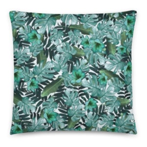 May include: A decorative throw pillow with a tropical leaf pattern in shades of green and white.
