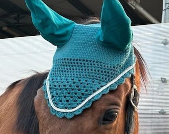 Anti-fly hat in teal green cotton yarn with tone-on-tone ears, decorated with rhinestones and pearl gray cord.