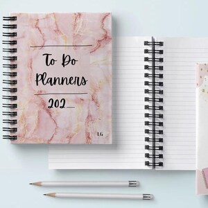 Pode incluir: Três cadernos de espiral com capas de mármore rosa e dourado. As capas apresentam o texto "To Do Planners 202" e "Because Organisation Is The Key To Success".