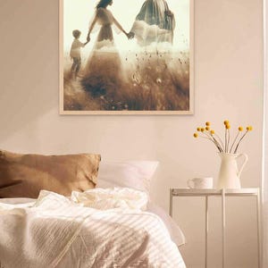 May include: A framed print depicts a family walking through a field. The figures are silhouetted against a cloudy sky, with a man, woman, and child holding hands. The artwork is displayed above a bed with white bedding and a brown pillow.