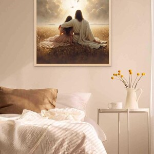 May include: A framed print depicts two figures embracing in a field, with a bright sky and birds overhead. The artwork is in a white frame and is displayed above a bed with white bedding. A small white table holds a vase of yellow flowers.