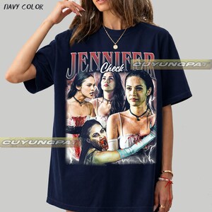 K&ouml;nnte beinhalten: Marineblaues T-Shirt mit einem Grafikdesign des Wortes "JENNIFER" in Rot und Wei&szlig;, darunter das Wort "Check". Die Grafik zeigt mehrere Bilder einer Frau mit dunklen Haaren und einem wei&szlig;en Kleid. Das T-Shirt ist marinefarben.