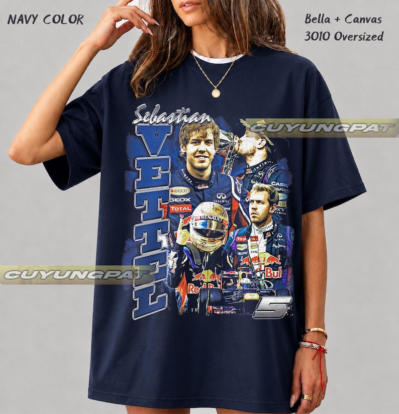 May include: A navy blue oversized t-shirt featuring a graphic print of Formula 1 driver Sebastian Vettel. The design includes the text "Sebastian VETTEL" and the number "5", along with multiple images of the driver in racing gear and a car.