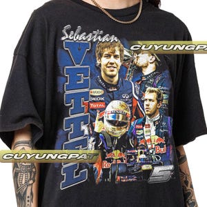 May include: Black t-shirt with a collage of images of Sebastian Vettel, a Formula 1 driver. The design includes his name, the word "Vettel" in blue, and images of him in racing gear and a race car. The shirt has a vintage appearance.