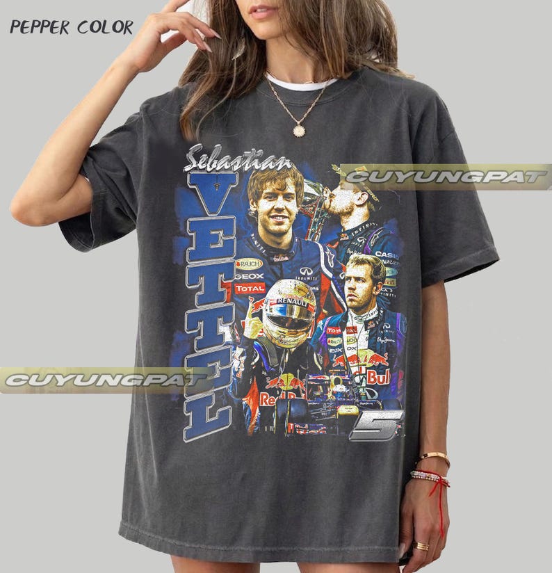 May include: A charcoal gray t-shirt featuring a graphic print of Formula 1 driver Sebastian Vettel. The design includes multiple images of the driver, his racing helmet, and the number 5, with the text Sebastian Vettel printed vertically.