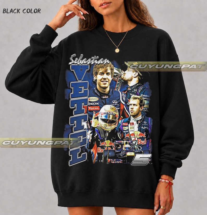 May include: A black crewneck sweatshirt featuring a graphic print of Formula 1 driver Sebastian Vettel. The design includes multiple images of the driver in racing gear, a racing helmet, a race car, the text "Sebastian VETTEL", and the number 5.