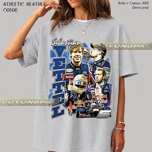 May include: An athletic heather gray oversized t-shirt featuring a graphic print of Formula 1 driver Sebastian Vettel. The design includes multiple images of the driver, a racing helmet, a race car, the number 5, and the text Sebastian Vettel.