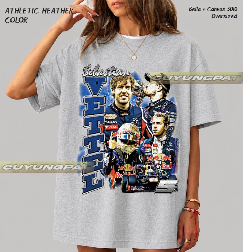 May include: An athletic heather gray oversized t-shirt featuring a graphic print of Formula 1 driver Sebastian Vettel. The design includes multiple images of the driver, a racing helmet, a race car, the number 5, and the text Sebastian Vettel.