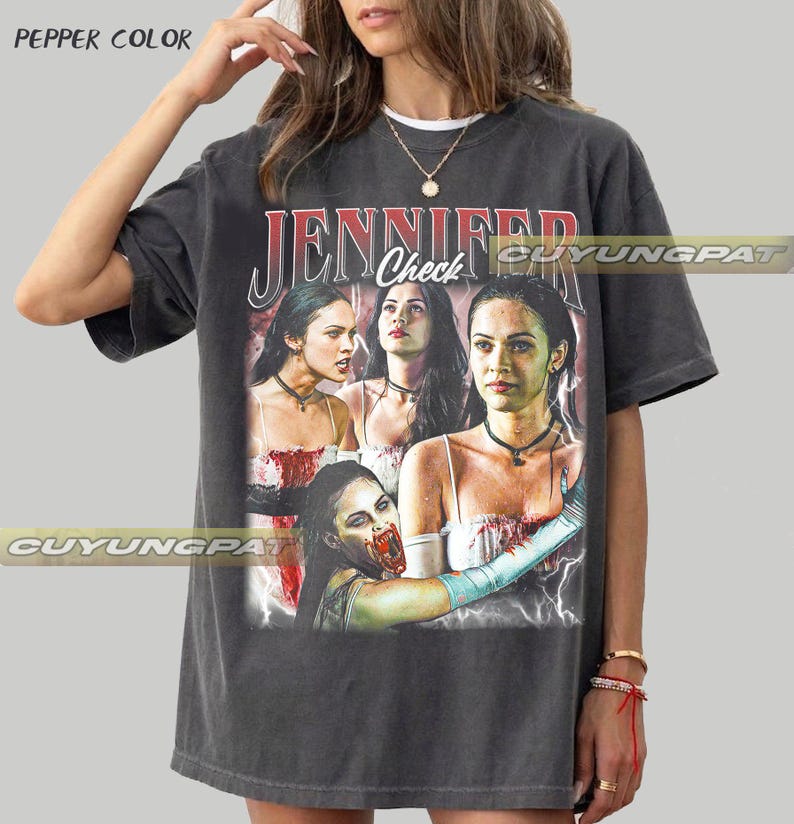 K&ouml;nnte beinhalten: Dunkelgraues T-Shirt mit einer Grafik einer Frau und dem Text "JENNIFER Check". Die Grafik enth&auml;lt mehrere Bilder der Frau. Das T-Shirt hat einen Vintage-Look.