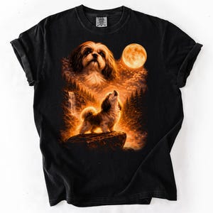 Puede incluir: Camiseta negra con un dise&ntilde;o gr&aacute;fico detallado de un perro aullando a la luna. El dise&ntilde;o incluye una luna llena, &aacute;rboles y una cascada, todo en tonos c&aacute;lidos de naranja y marr&oacute;n. El perro es el punto focal, sobre un cielo nocturno.