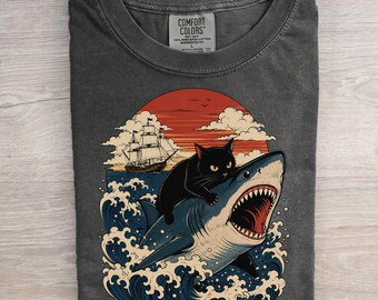 太った猫対サメのシャツ、ミームの面白い猫がサメに乗っている面白い海のグラフィックTシャツ、レトロな日本スタイルのかわいい子猫のコンフォートカラーTシャツ