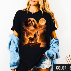 Puede incluir: Camiseta negra con un gr&aacute;fico detallado de un perro aullando a la luna en un entorno forestal. El dise&ntilde;o incluye una luna llena y una cascada. El texto "COLOR: BLACK" est&aacute; en la parte inferior derecha.
