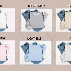 May include: Six long-sleeved shirts in different colors, laid flat on a white surface with a pair of jeans folded underneath each shirt. The colors are white, sport grey, sand, light pink, light blue, and ash.
