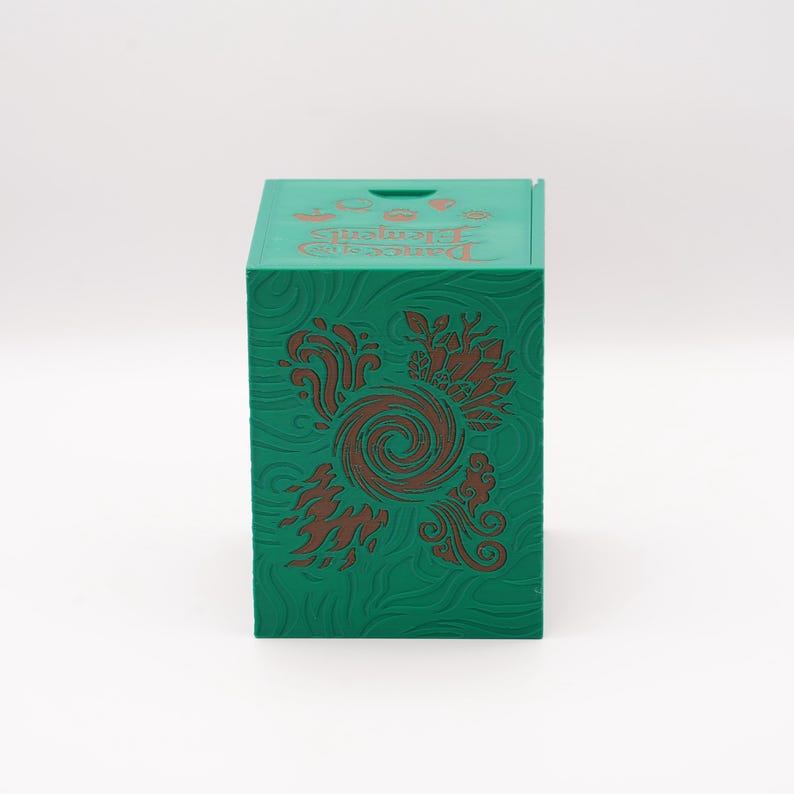 May include: A green box with embossed floral designs and the words "Dungeons & Dragons Elements" in orange. The box is square and has a slot on the top. The floral design is a reddish-brown color.