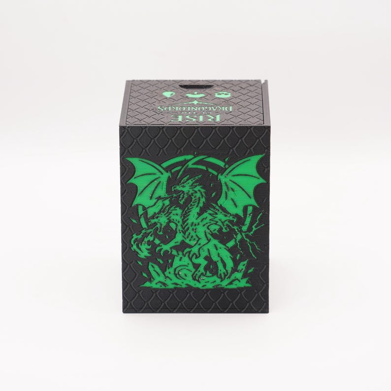 May include: Black box with a green dragon graphic. The box has a textured surface and the words "RISE DRAGONFORDS" are printed on the top. The dragon is depicted with wings and a detailed body.