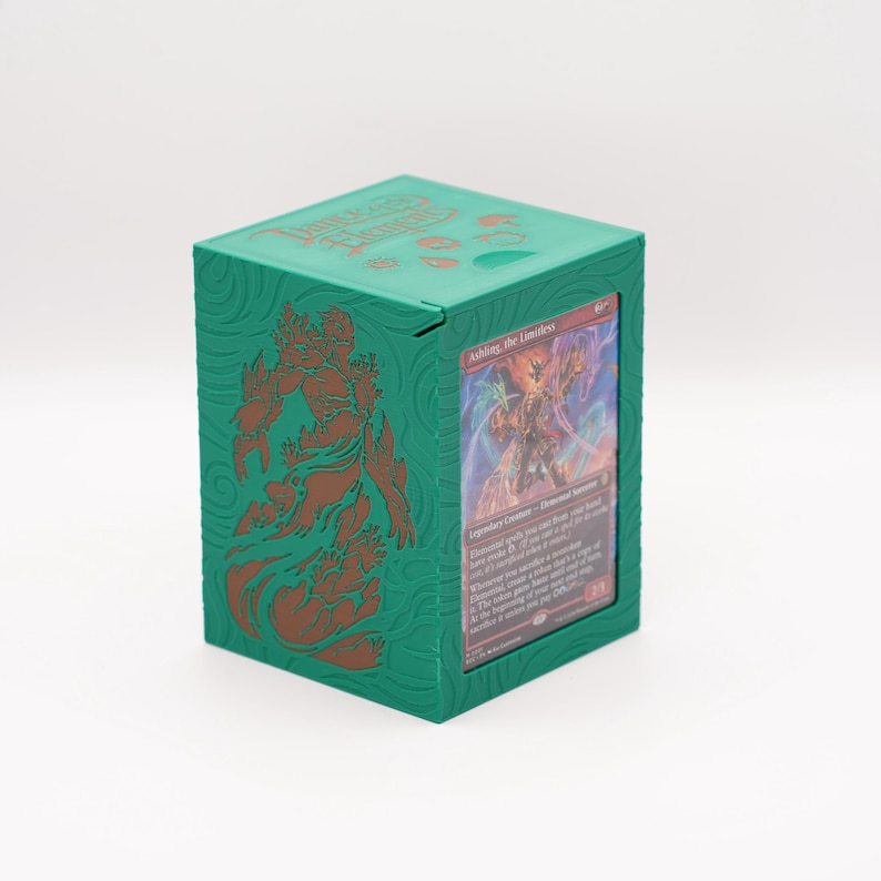 May include: A green card storage box with a hinged lid. The box features a detailed embossed design in a darker green color. A card is visible in the front, showcasing a fantasy illustration. The text "Dungeons & Dragons" is visible on the top of the box.