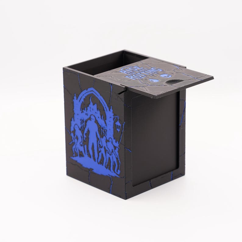 May include: Black box with a hinged lid, featuring a blue graphic of a haunted house scene with figures. The lid has the text "RISE ABOVE ROTING" in blue. The box has a distressed, cracked appearance.