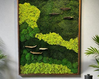 May include: A large rectangular framed wall art piece featuring a vibrant moss design in shades of green and yellow. Several wooden accents are placed on the moss. The artwork hangs above a wooden cabinet with a book and decorative items.