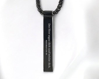 Könnte beinhalten: Eine schwarze Kettenkette mit einem rechteckigen Anhänger, auf dem "Der Herr segne dich und behüte dich." (Numeri 6,24-26) steht.