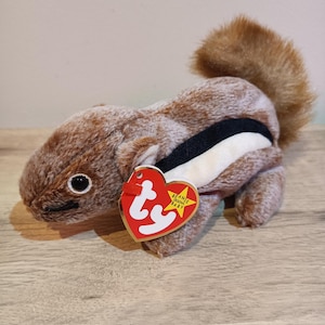 May include: Brown and white striped beanie baby squirrel plush toy with a red and white Ty tag that says "Beanie Babies Baby".
