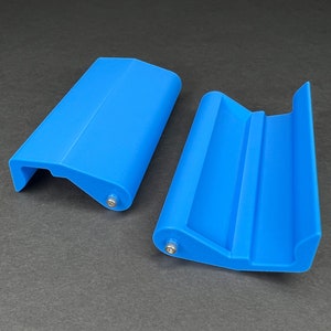 May include: Two blue plastic door handles with a curved design and a silver screw in each handle.