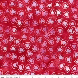 May include: Red fabric with a pattern of white and pink hearts. The hearts have a white outline and a pink interior. The fabric is marked with inches along the bottom.