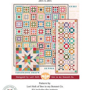Könnte beinhalten: Ein farbenfrohes Quiltmuster für einen Tischaufsatz oder ein Kissen, mit den Maßen 62,2 x 62,2 cm. Das Design zeigt ein Patchwork aus sternförmigen Blöcken in verschiedenen Farben. Das Bild enthält auch einen Läufer und ein kleineres Kissenmuster. Entworfen von Lori Holt.