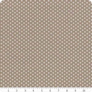 Op de afbeelding: Tan stof met een herhalend patroon van kleine witte bloemmotieven. De stof heeft een getextureerde uitstraling en is geschikt voor quilt-, naai- of andere knutselprojecten. Het patroon is gelijkmatig verdeeld over de stof.