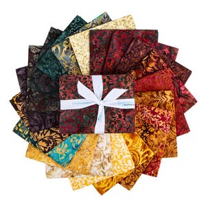 May include: A circular arrangement of folded fabric squares featuring batik-style patterns in a spectrum of colors including deep red, gold, teal, and dark green. A white ribbon is tied around the center stack with the text Expression.