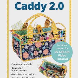 Può includere: Un organizer Catch All Caddy 2.0 blu navy e con motivo floreale con accenti gialli. L'organizer ha un design robusto, divisori interni espandibili, tasche esterne e manici imbottiti. Il testo "Catch All Caddy 2.0" è incluso.