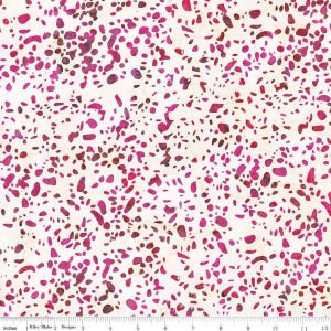 May include: Fabric with a speckled pattern in shades of pink and burgundy on a cream background. The fabric has a ruler along the bottom edge with the text "Inches" and "Riley Blake Designs".