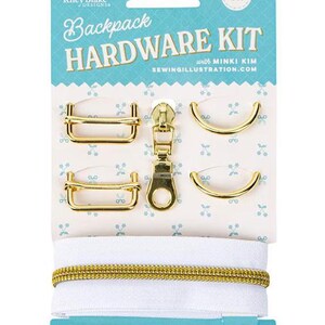 Puede incluir: Un kit de herrajes para mochila de 6 piezas de Riley Blake Designs. El set incluye dos deslizadores rectangulares, dos anillas en D, un tirador de cremallera y una cinta de cremallera blanca con dientes dorados sobre una tarjeta.
