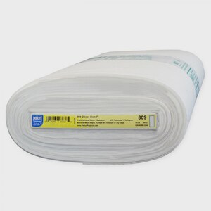 May include: A roll of white fabric labeled "809 Decor-Bond" with a barcode and product information. The fabric is 45 inches wide and made in the USA. The roll is tightly wound and appears to be new.