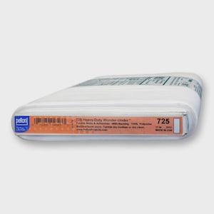 May include: A roll of white Pellon 725 Heavy-Duty Wonder-Under fusible webs and adhesives. The label includes product information, care instructions, and the text "MADE IN USA". The roll measures 17 inches in width.