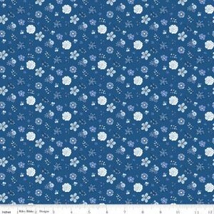 May include: A fabric with a repeating floral pattern in shades of blue and white. The design features various flower shapes and small leaf clusters on a dark blue background. The ruler at the bottom shows measurements in inches.