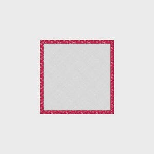 Pode incluir: Um tecido quadrado branco com um padrão texturizado, emoldurado por uma borda vermelha vibrante. A borda é adornada com um design floral repetitivo. A estética geral é simples e elegante.