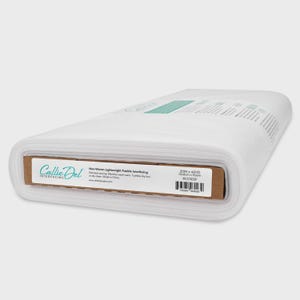 May include: A roll of white non-woven lightweight fusible interfacing fabric. The label reads "Callie Del Interfacing" and "20IN x 40YD". The fabric is used for garment sewing and is machine washable. The roll is 20 inches wide and 40 yards long.