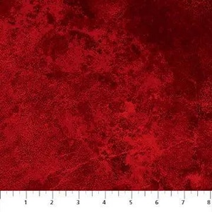 Op de afbeelding: Een stuk stof met een gevlekte, dieprode en karmozijnrode textuur met donkere schaduwen en lichtere accenten. Aan de onderkant is een witte liniaal zichtbaar met metingen in centimeters van één tot acht, wat de schaal van het patroon aangeeft.