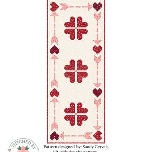Peut inclure: Un kit de chemin de table pour la Saint-Valentin avec un fond crème et des motifs de cœurs et de flèches rouges. La taille finie est de 52,7 cm sur 132,7 cm. Le kit comprend le patron et le tissu. Le tissu est de la collection "Love You Always".
