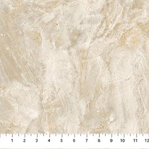 May include: Close-up of a beige and cream-colored marble-like surface. The surface has a natural, veined pattern with variations in color and texture. A ruler is at the bottom, showing measurements in inches.