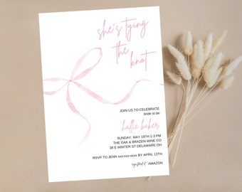May include: A pink watercolor ribbon tied in a bow with the text "she's tying the knot" above it. The text "Join us to celebrate bride to be Hallie Baker" is below the bow. The invitation details the date, time, location, and RSVP information.